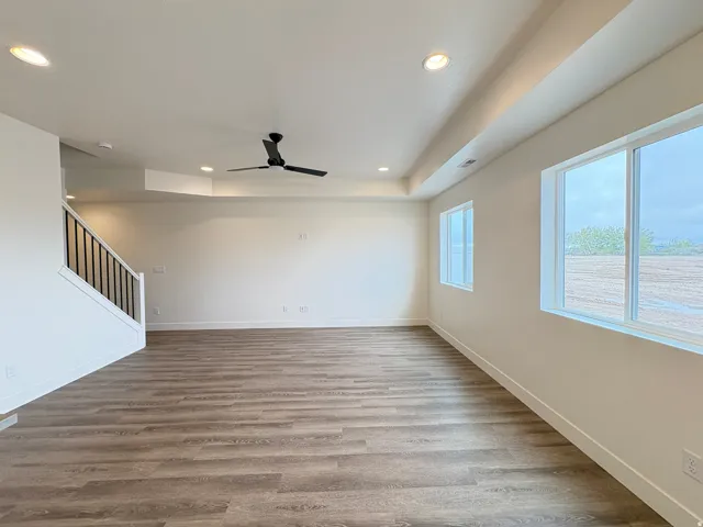 Wood-finish flooring, recessed lighting, and a contemporary ceiling fan