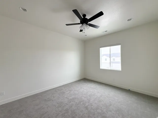 Recessed ceiling lighting, ceiling fan, carpet flooring, window, and neutral wall finish