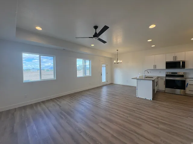 Open-concept living area featuring wood-finish flooring, recessed lighting, and a contemporary ceiling fan