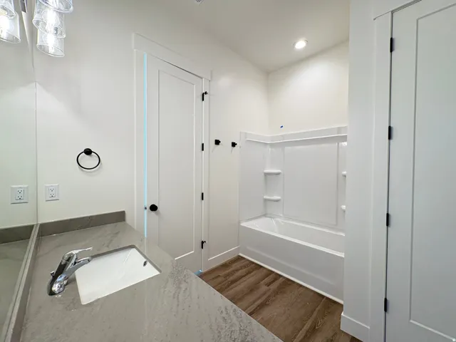 Integrated vanity with a single basin sink, chrome faucet, and stone countertop