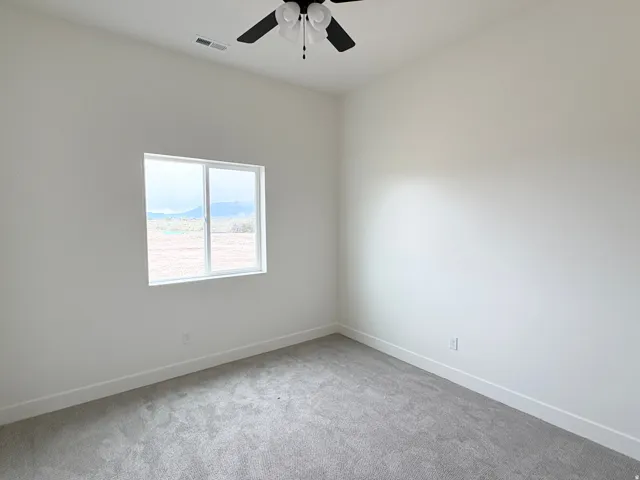 Ceiling fan with light fixture, wall-to-wall carpeting, single window, and white painted walls