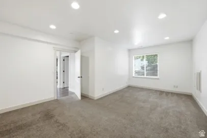 Carpeted flooring, recessed lighting, white walls, and a window with horizontal blinds