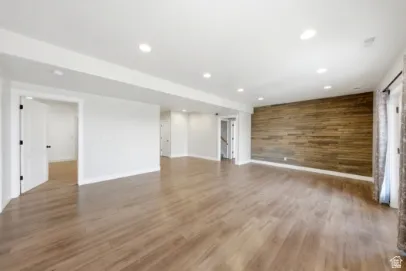 Wood-finish flooring, recessed lighting, and a prominent wood-panel accent wall