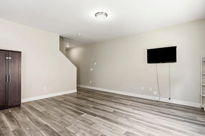 Wood-finish flooring, staircase with recessed lighting, and a flush mount ceiling light fixture