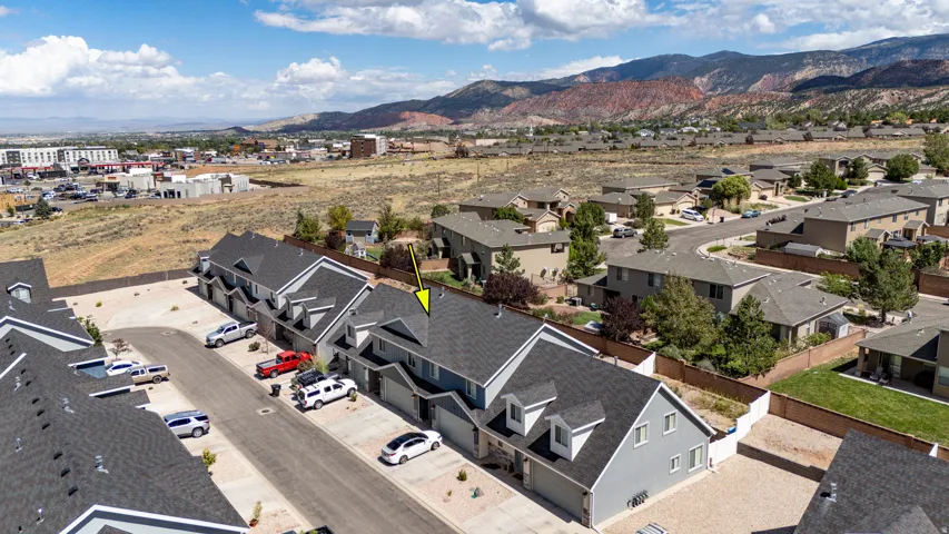 Townhome community with asphalt shingle roofs, attached garages, and a paved street