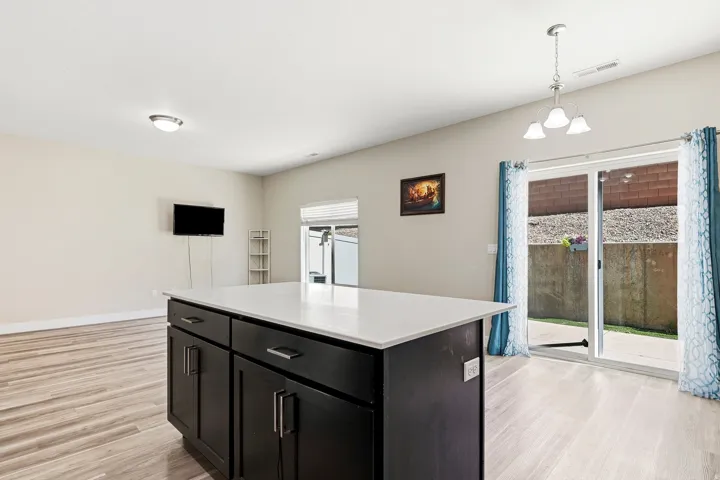 Kitchen island with dark cabinetry and a light-colored countertop