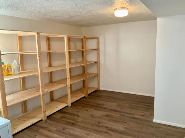 Wood-finish flooring with light-toned walls and built-in shelving units