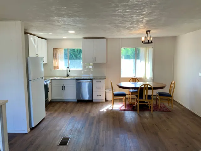 Kitchen area featuring white cabinetry, light-colored countertops, and stainless steel appliances