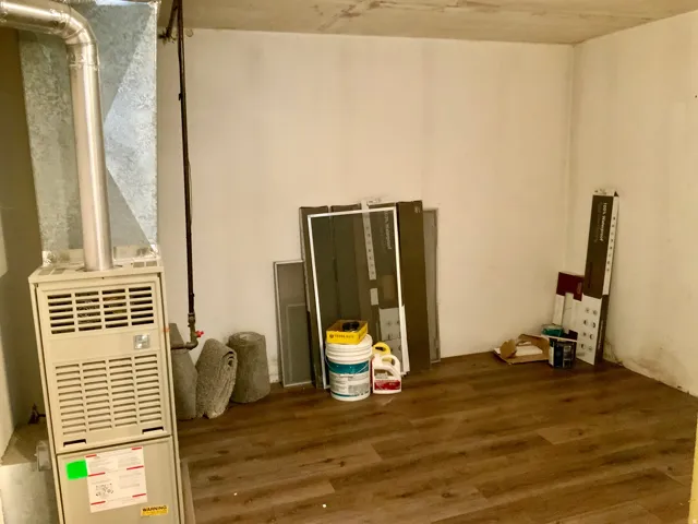 Wood-finish flooring with white walls and exposed ductwork