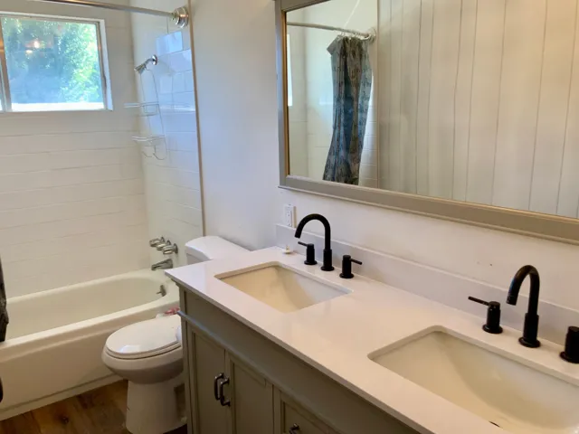 Double vanity with integrated sinks, quartz-finish countertop, and matte black fixtures
