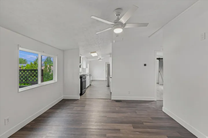 Wood-finish flooring, white walls, and a contemporary ceiling fan with integrated lighting