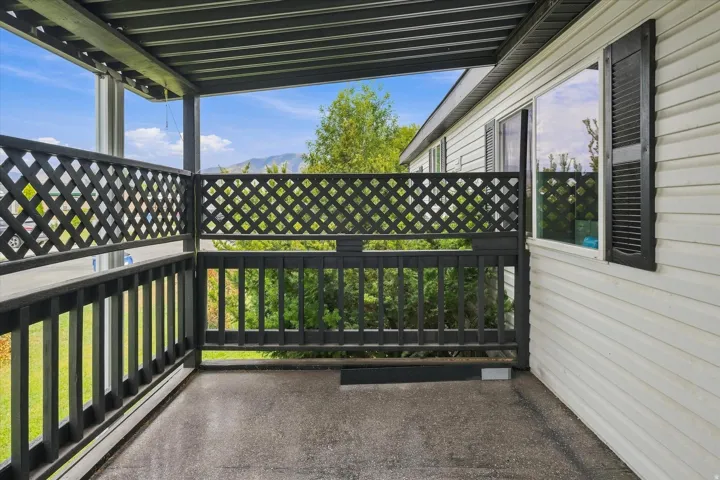 Covered balcony with lattice railing and a metal overhang