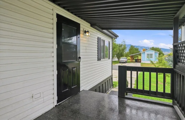 Covered deck with composite decking and black aluminum railings, offering mountain vistas