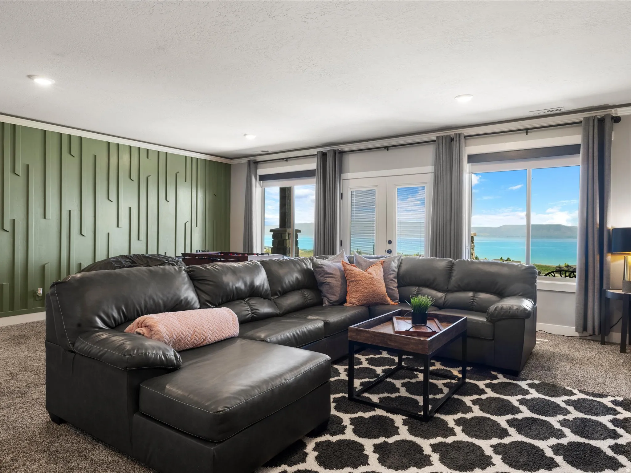 Expansive windows, French doors, recessed lighting, and a decorative accent wall