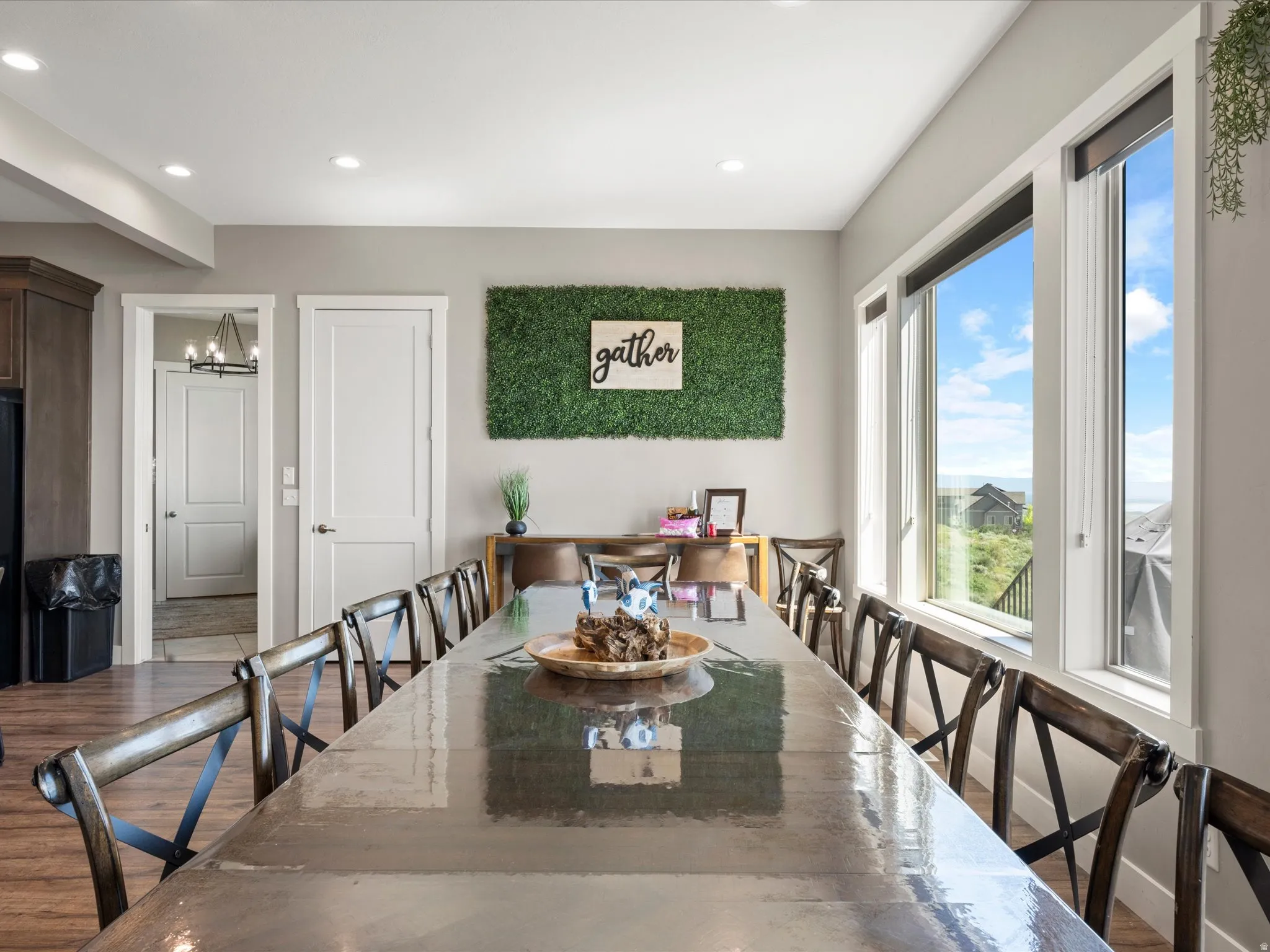 Spacious room featuring multiple large windows, recessed ceiling lighting, light gray walls, and wood-finish flooring
