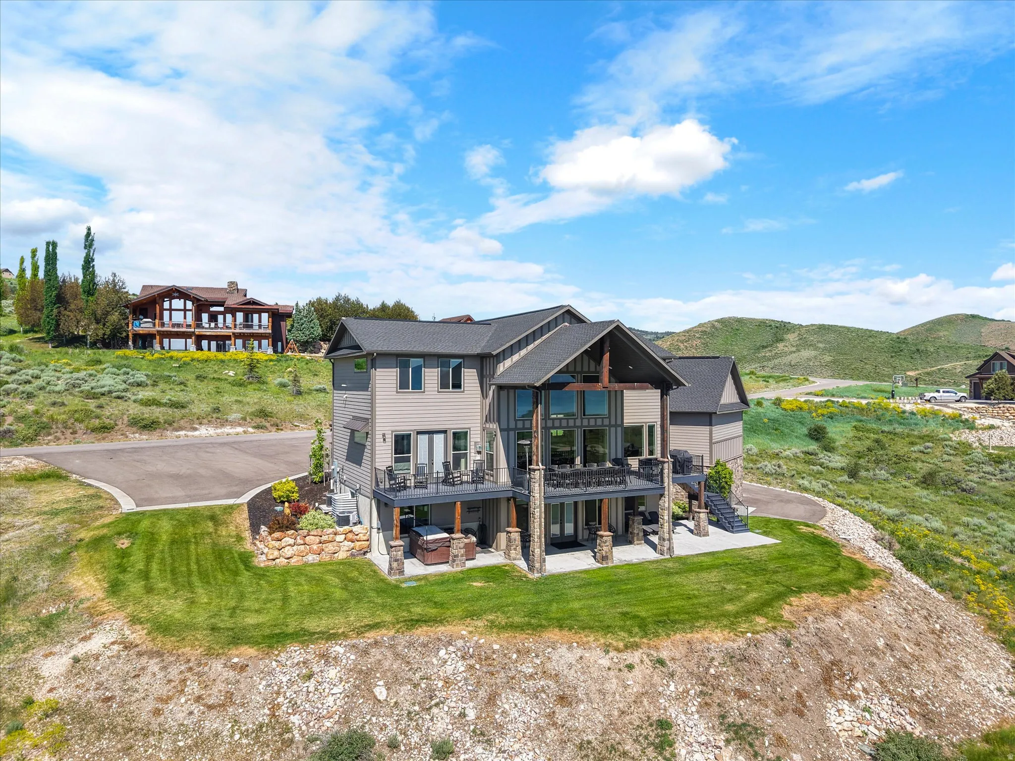 Expansive multi-level property with a stone and siding exterior, multiple outdoor decks, and a private hot tub area