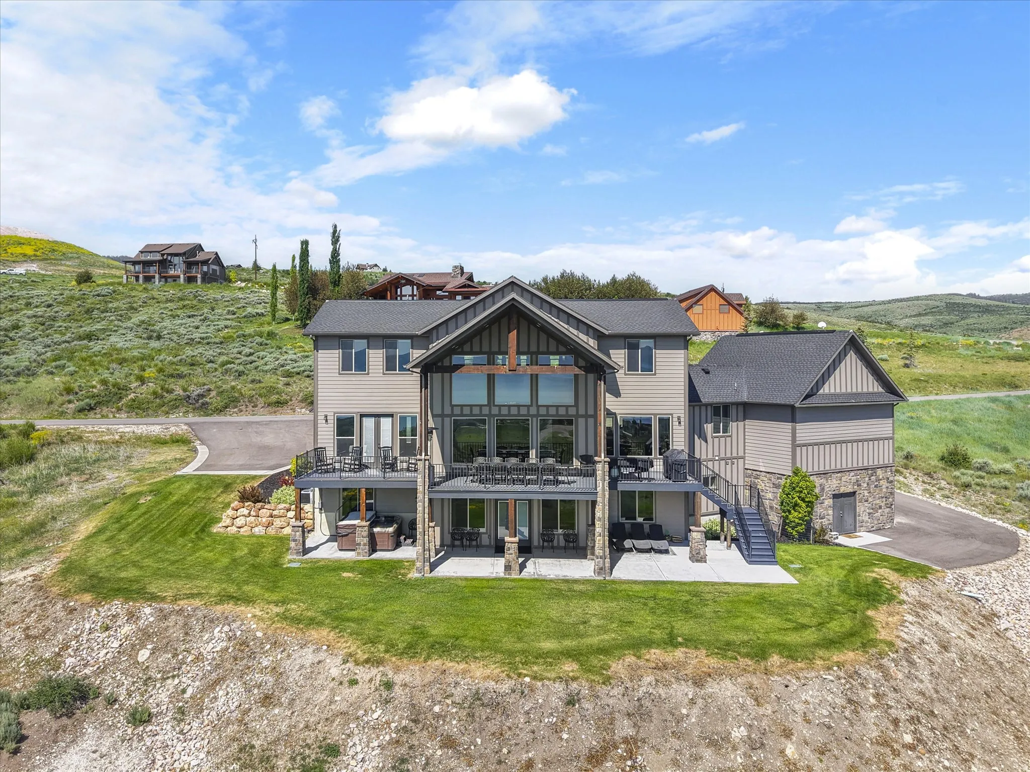 Multi-level dwelling with extensive deck space, large windows, and an integrated garage