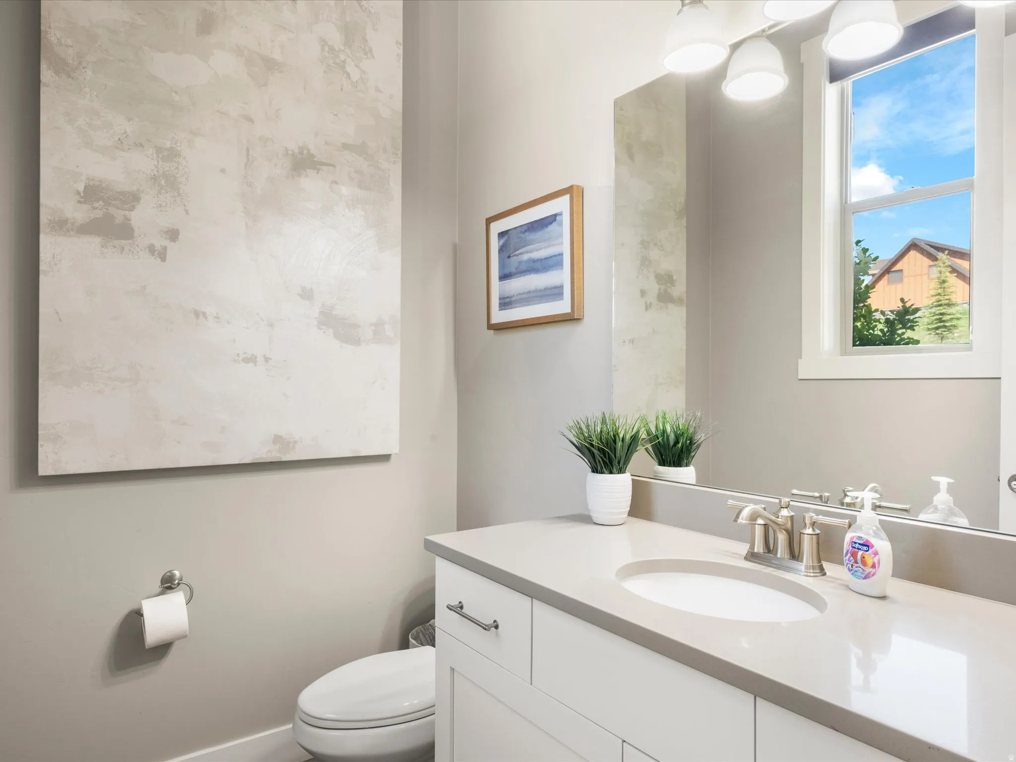 White vanity with brushed nickel hardware and integrated oval sink