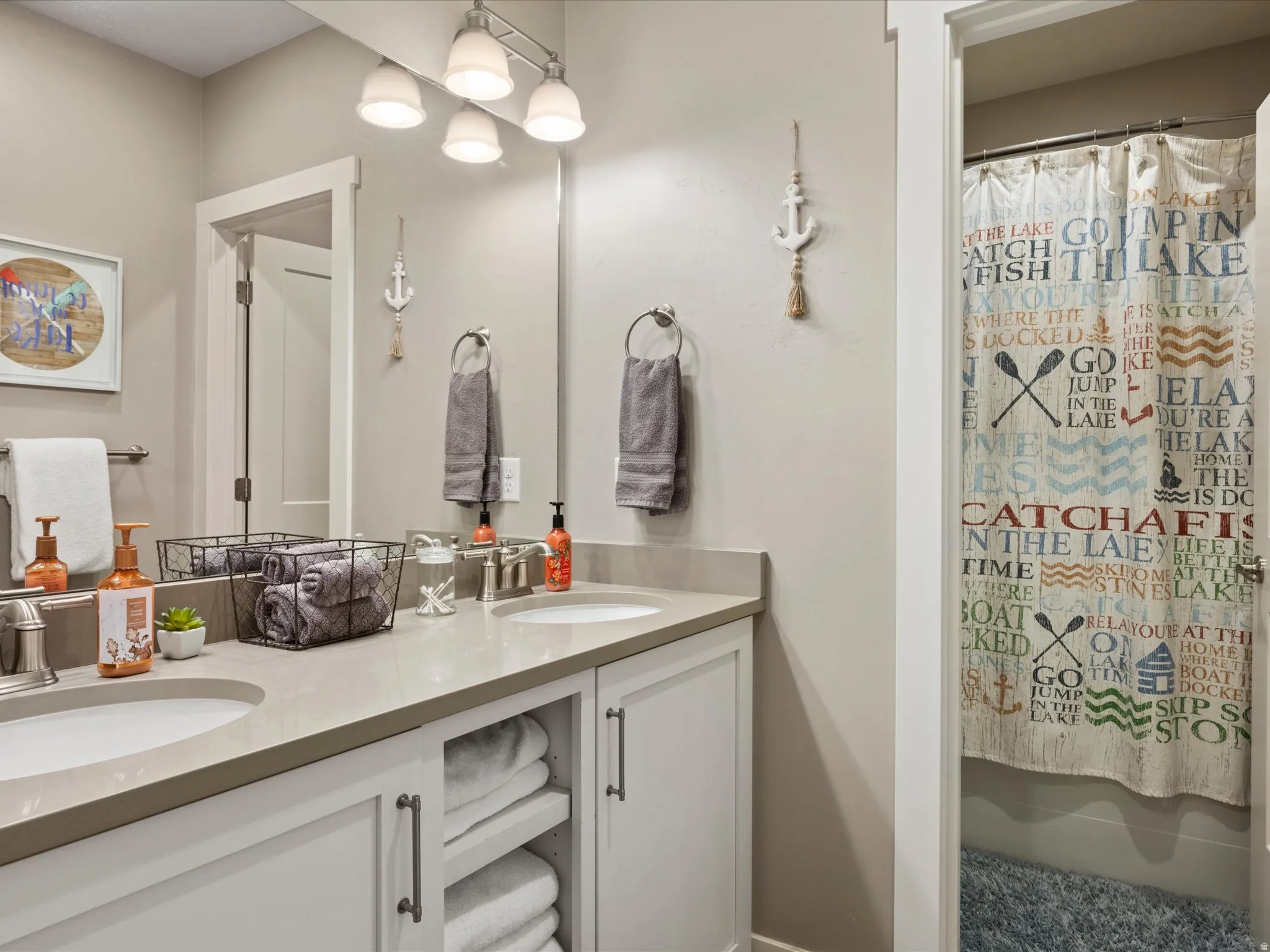 Dual vanity with integrated sinks, ample countertop space, under-cabinet storage, and brushed nickel fixtures