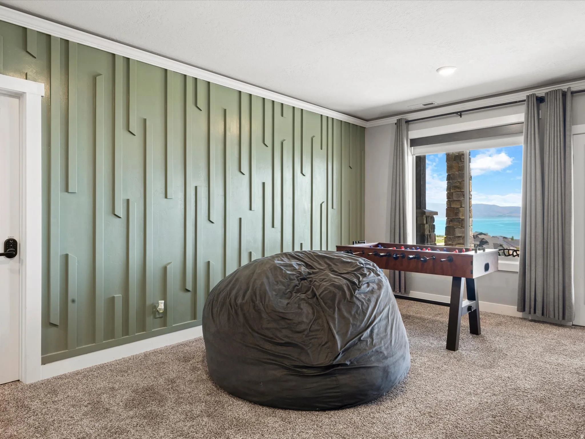 Accent wall with vertical paneling, carpeted flooring, large window, and recessed lighting