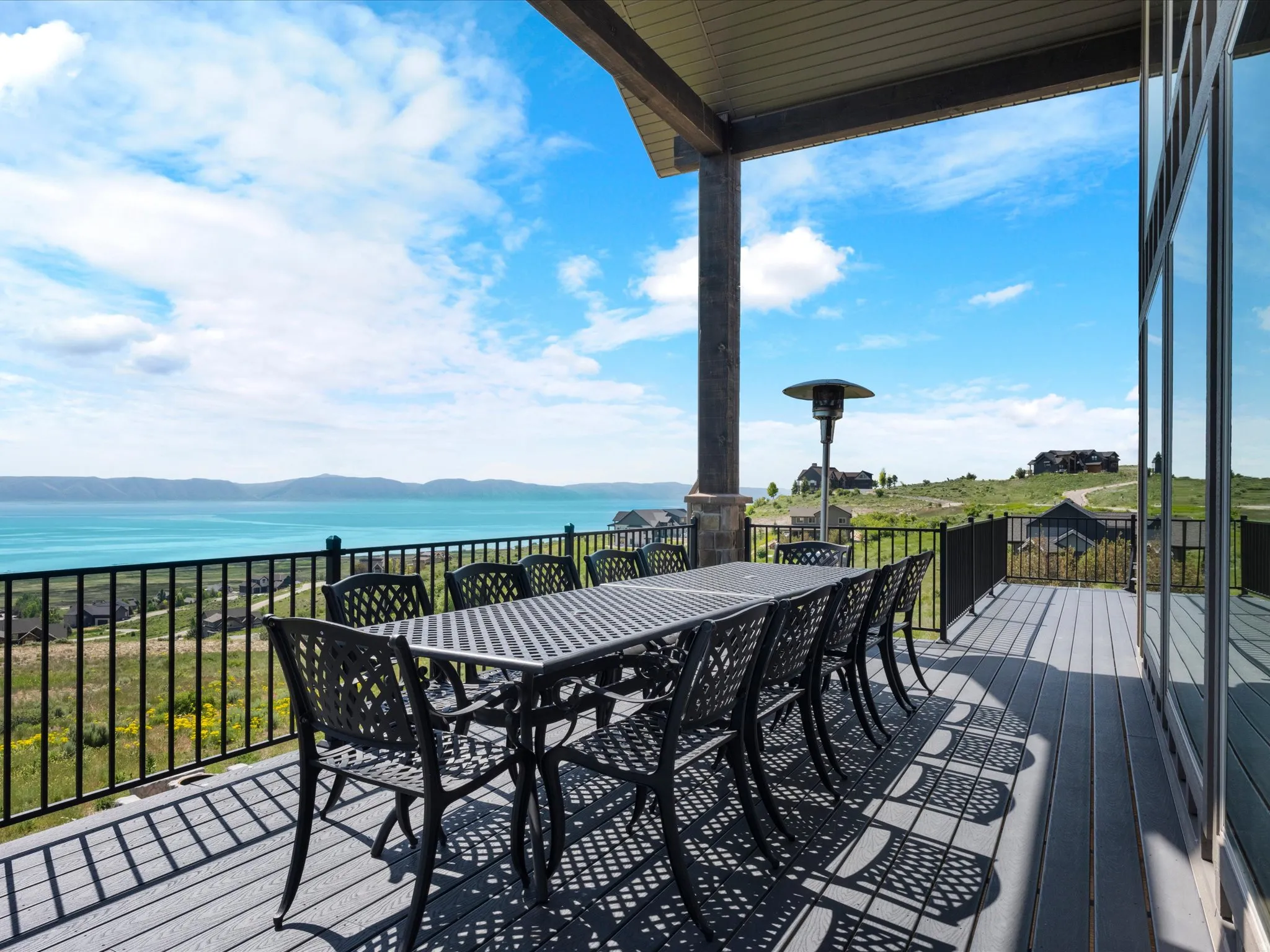 Expansive covered deck with composite decking, metal railing, and large glass doors