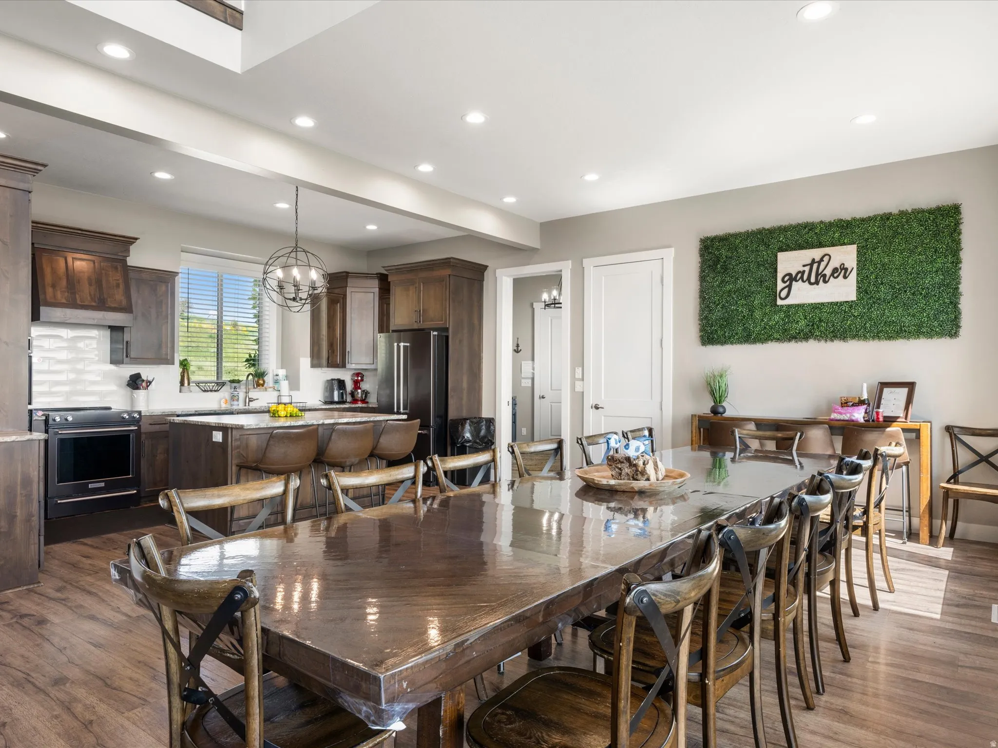 Open-concept great room featuring wood-finish flooring, recessed lighting, and a kitchen island with seating