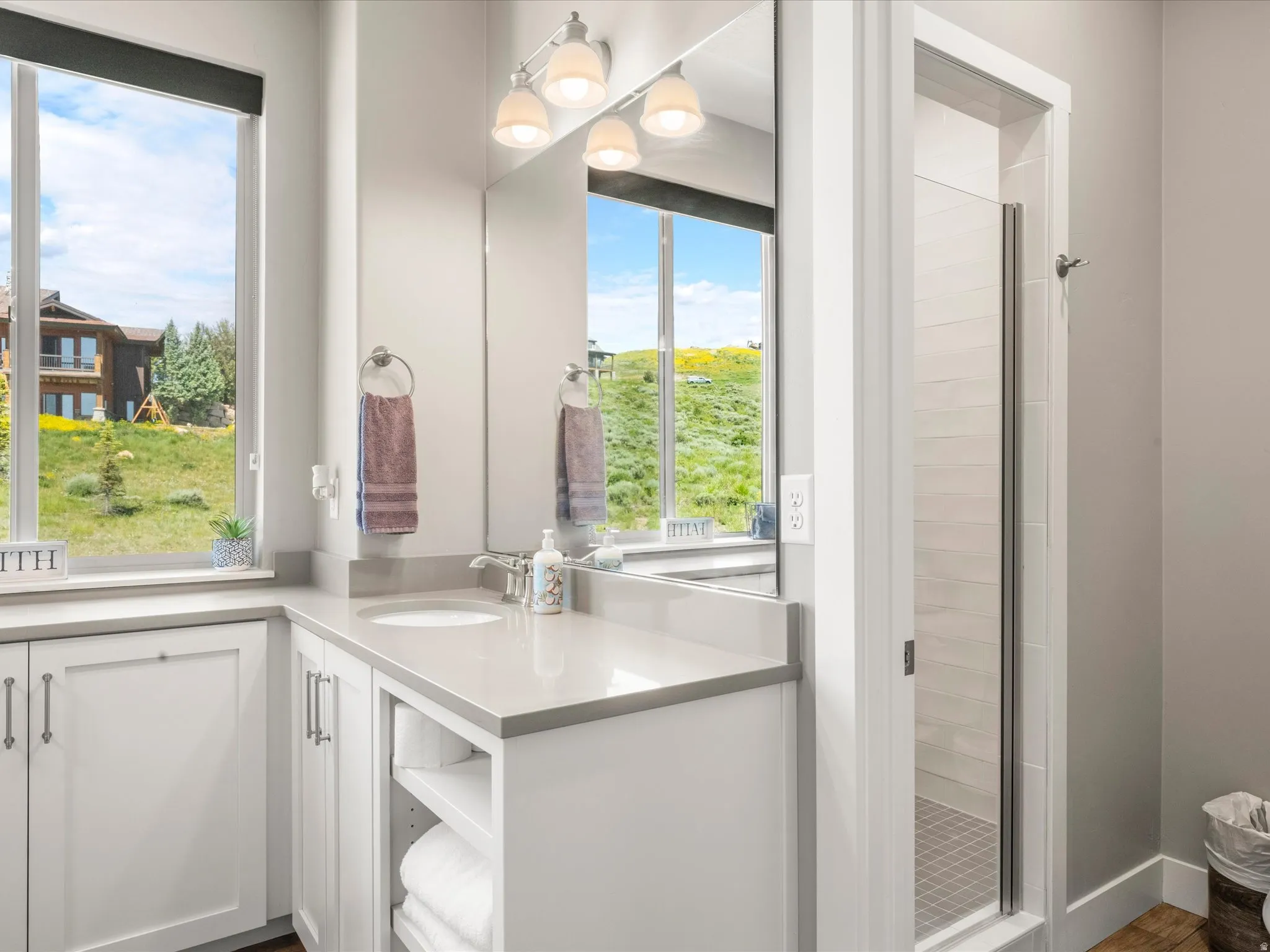 White single vanity with under-mount sink, light-toned countertop, and white cabinetry