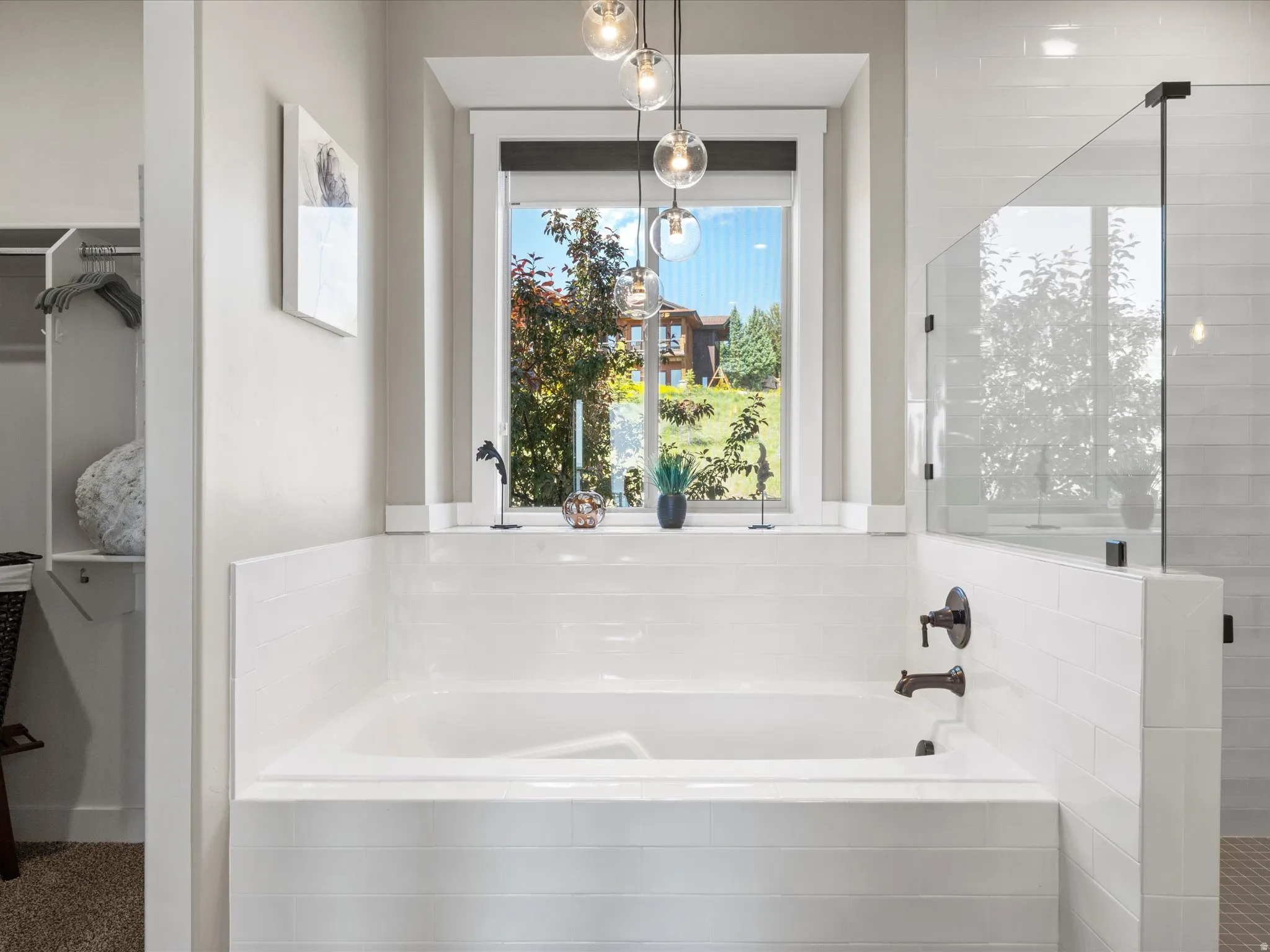 Soaking tub with a tiled surround, bronze-finish fixtures, and a glass-enclosed shower