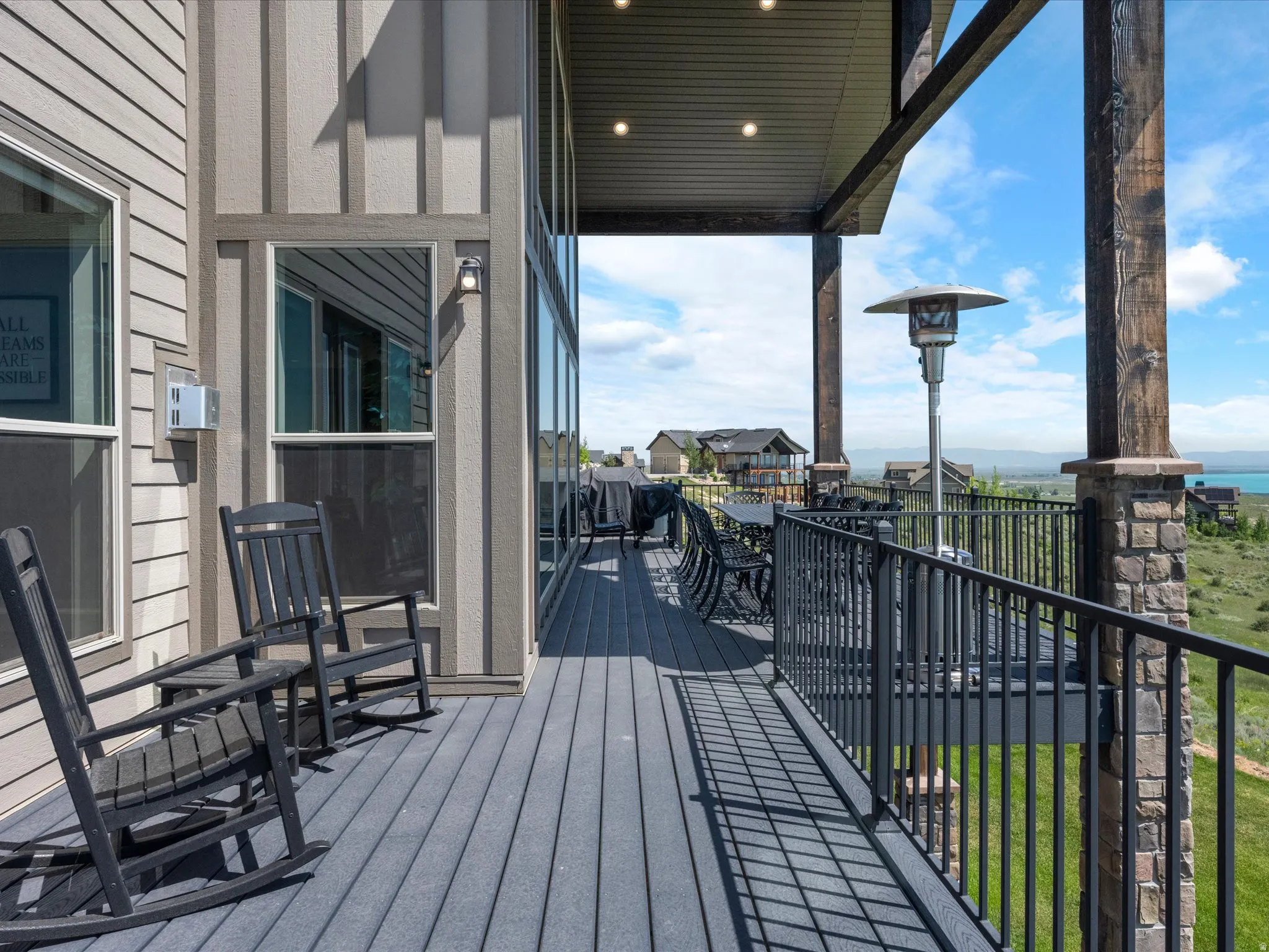 Expansive outdoor deck with composite decking, black metal railings, and integrated overhead lighting