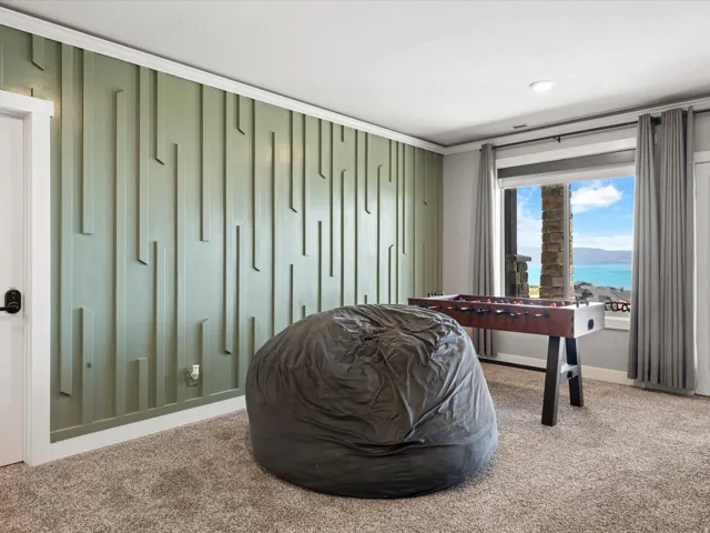 Accent wall with vertical paneling, carpeted flooring, large window, and recessed lighting
