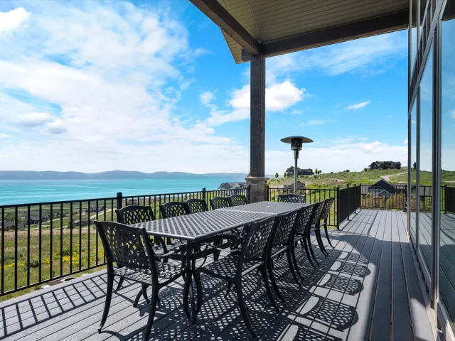 Expansive covered deck with composite decking, metal railing, and large glass doors