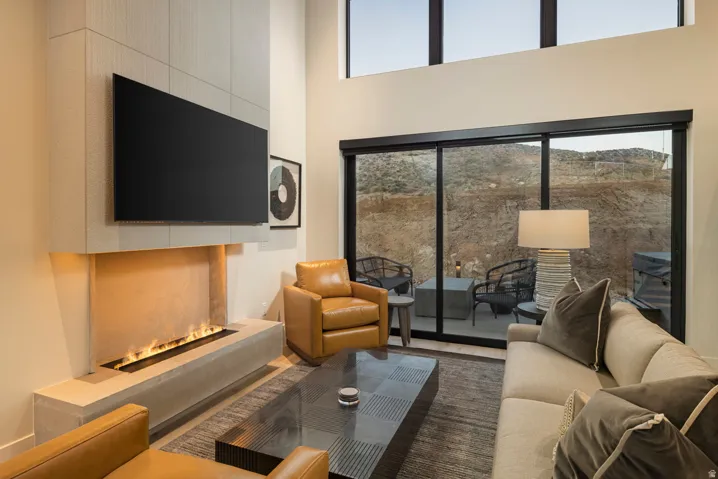 Living area featuring a floor-to-ceiling fireplace with a linear burner, high ceilings, and expansive sliding glass doors