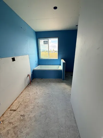 Built-in tub with surrounding enclosure, window with outdoor scenery