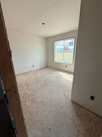 Drywall-finished walls and ceiling with an electrical outlet and overhead lighting provision