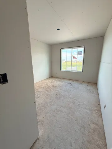 Unfinished room with natural light, drywall-finished walls, and subfloor