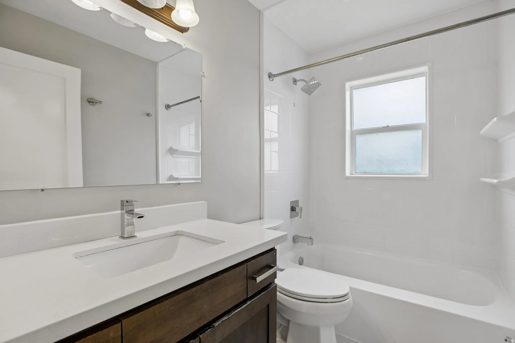 Dark wood-finish vanity with integrated sink, white countertop, and polished chrome faucet