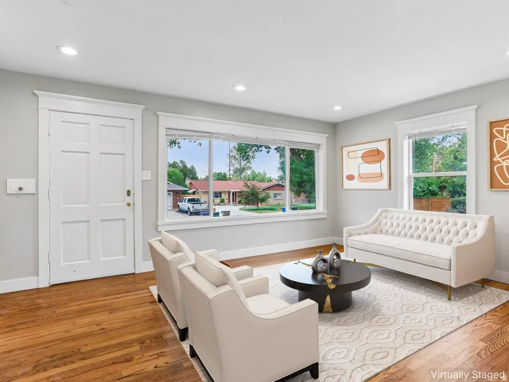 Hardwood-finish flooring, recessed lighting, multiple windows, and a panel door