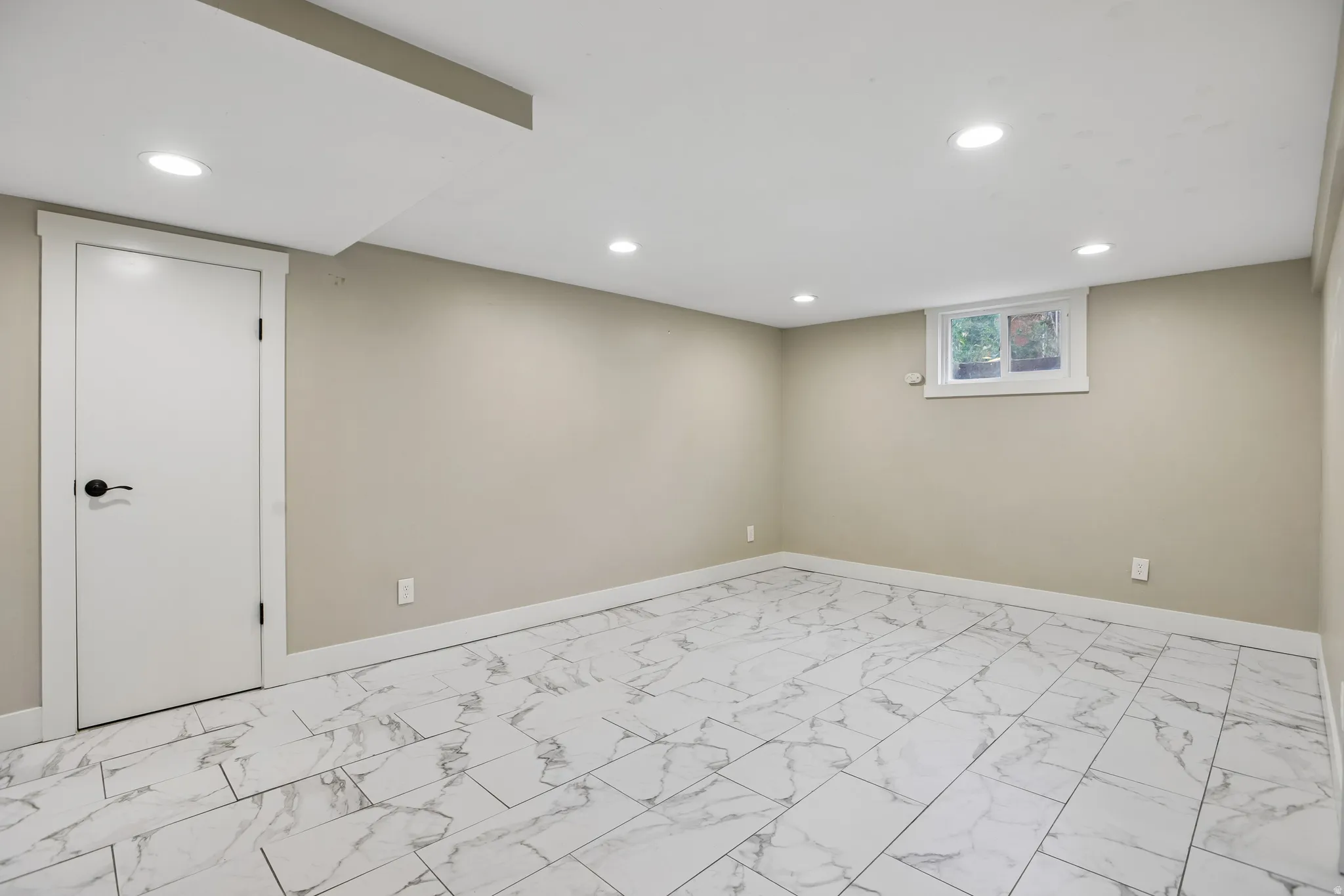 Recessed lighting, light-colored walls, white trim, white door, and tiled flooring