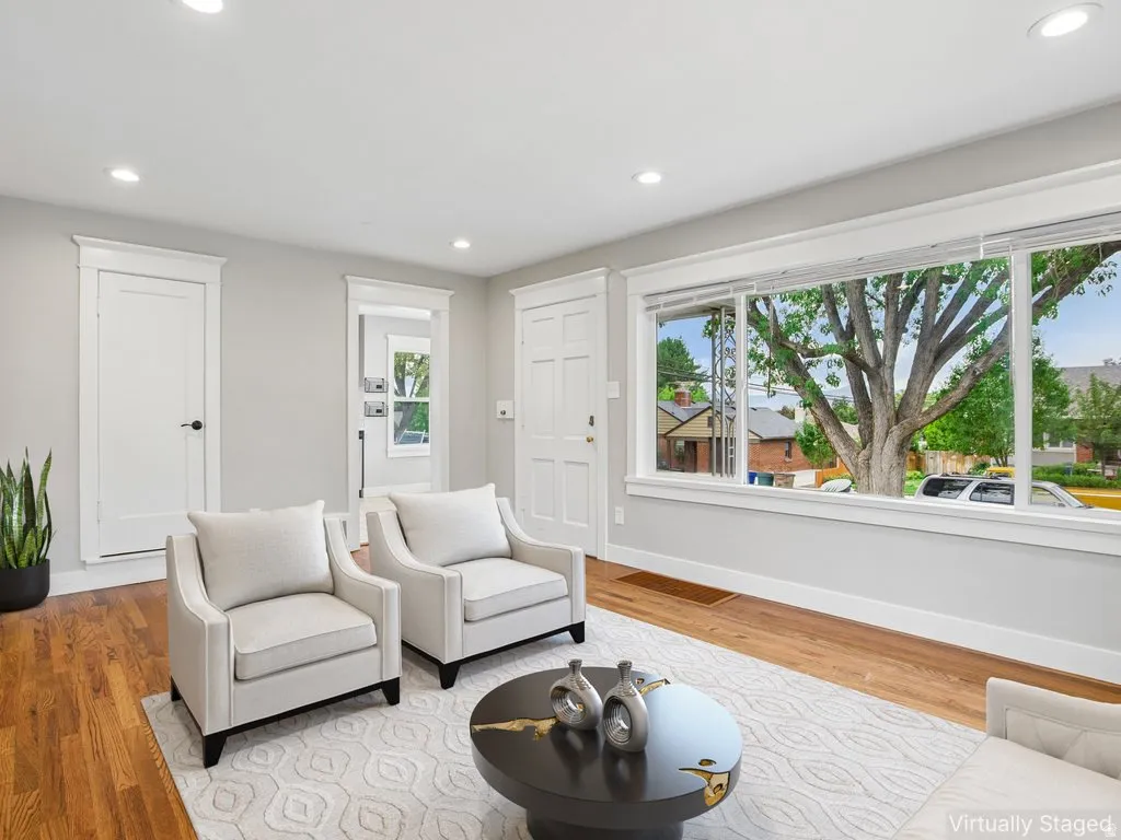 Hardwood flooring, recessed lighting, white trim, expansive windows, and a neutral wall color