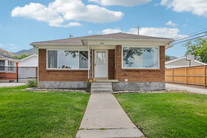 Brick exterior with an entryway, a covered porch, and a concrete walkway