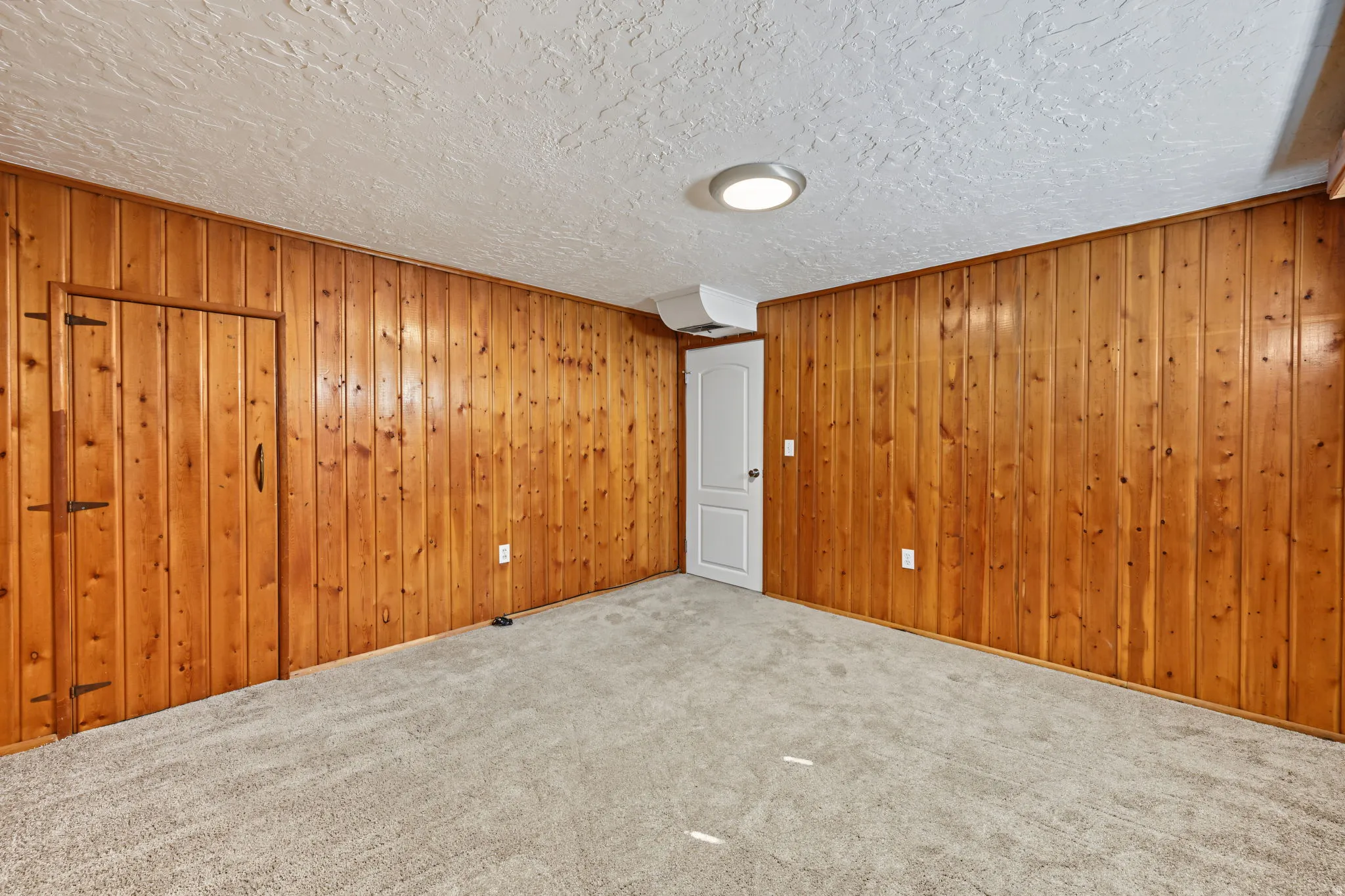 Bedroom four with wood-paneled walls and upgraded carpet