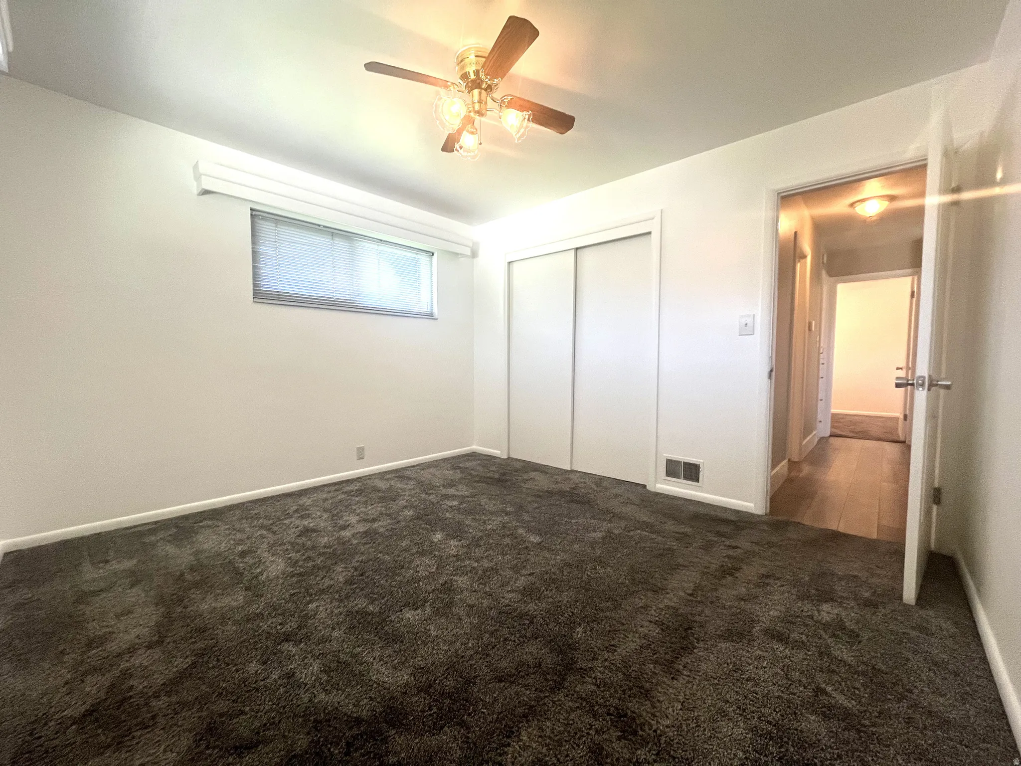 A second peek of the primary bedroom looking toward the closet and entry door