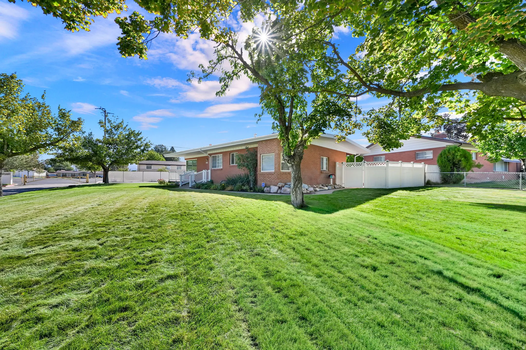 This spacious corner lot offers privacy and mountain views, paired with a lush green lawn, mature trees and automatic sprinklers