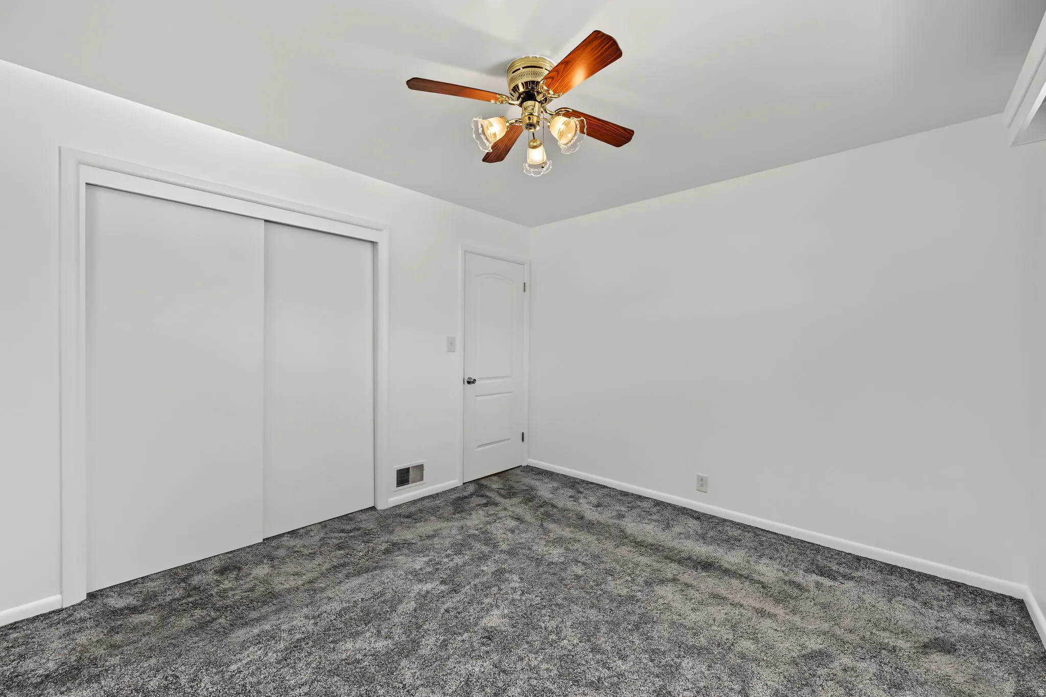 Relaxing primary bedroom featuring gray carpeting, dual windows for natural light, and a comfortable layout.