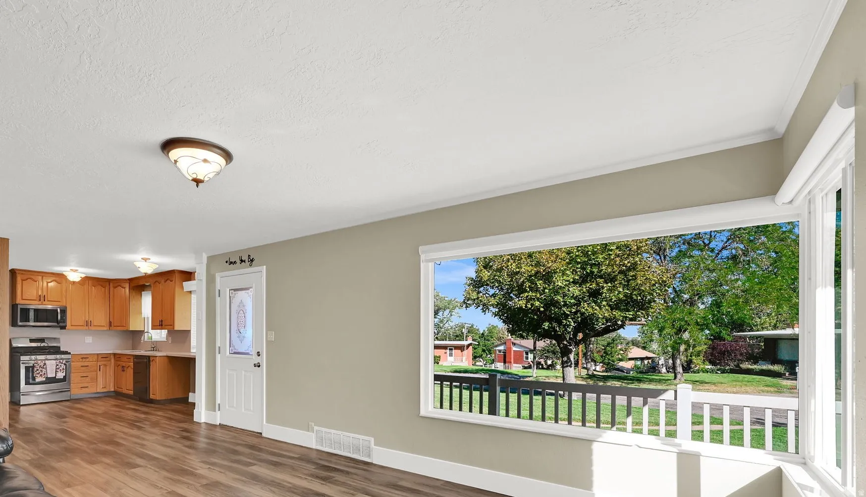 At the heart of the home sits a welcoming living area where picture windows fill the space with light, making it the perfect backdrop for loved ones to gather