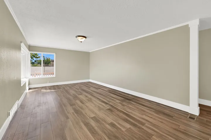 The modern living/family room features warm wood laminate floors and neutral walls that create a bright, open space