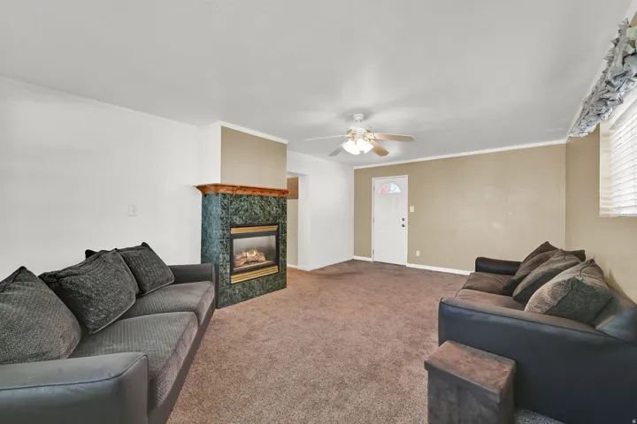 Enjoy twice the living space with a second family room featuring neutral paint and carpet, a cozy gas fireplace, and direct backyard access to a covered patio.