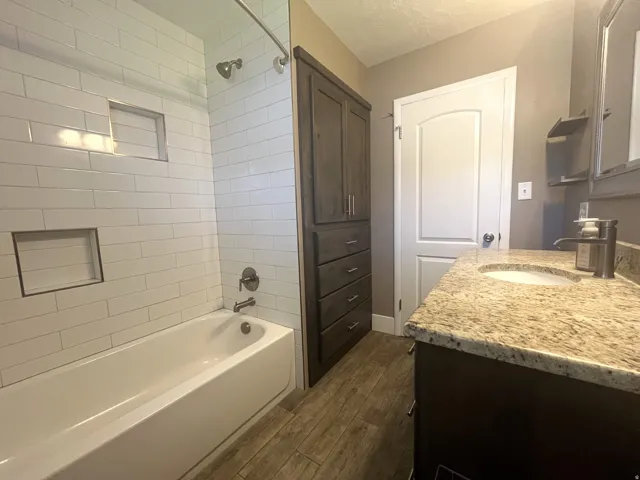 A subway-tile tub/shower combo with integrated niches elevates the space, while custom built-in cabinetry seamlessly stores your beauty supplies and essentials.