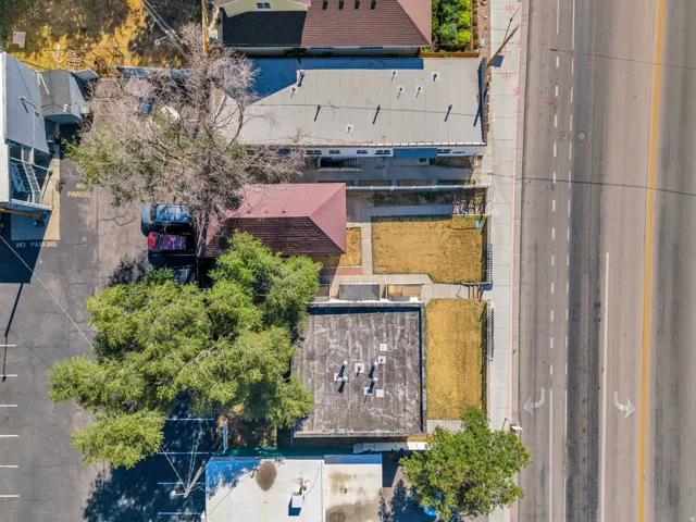 Properties featuring street access, adjacent asphalt parking, mature trees, and multiple structures