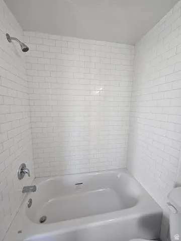 Bathtub with white subway tile surround and chrome fixtures